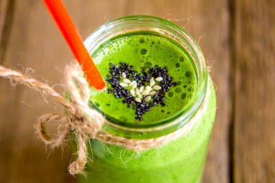 Green vegetable and herbs smoothie with heart of poppy and sesame seeds. Love for a healthy raw food concept.